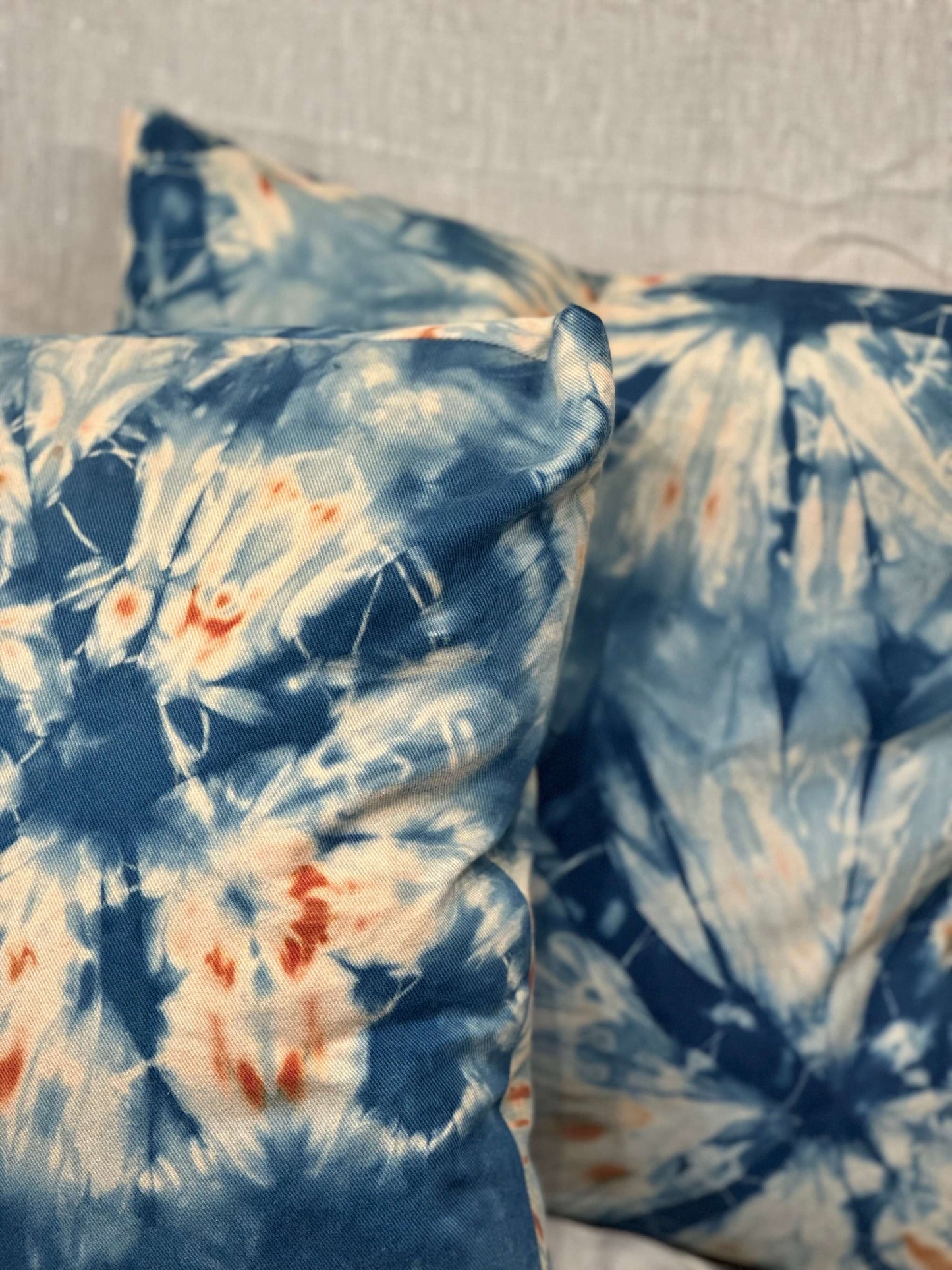 Close up of Hand-dyed indigo shibori pillow cases with sand dollar design.