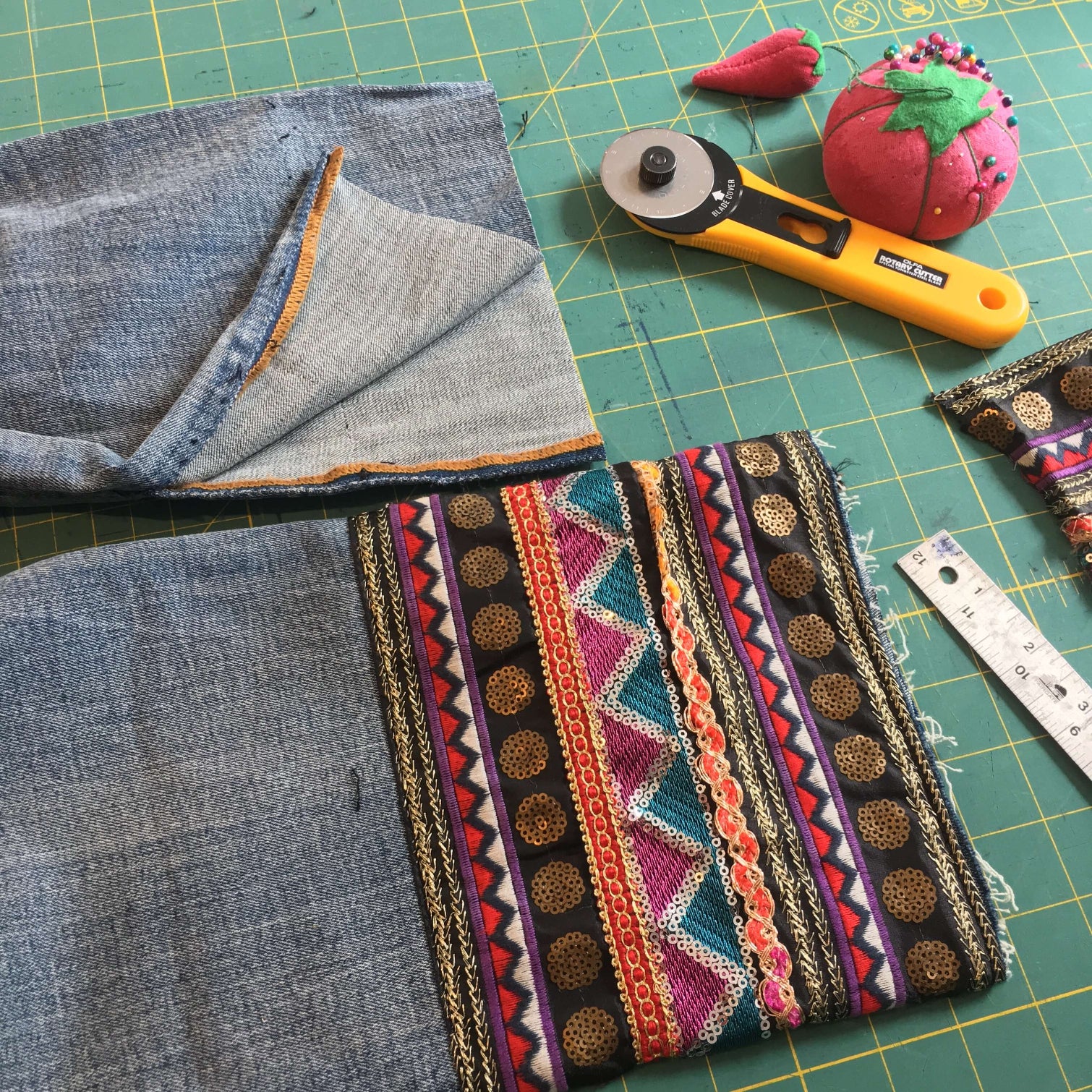 A sewing workshop setup with a sewing machine, colorful fabric, and a measuring tape on a table.